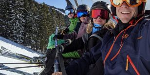Skiers on a lift telling solo ski holidays stories and experiences