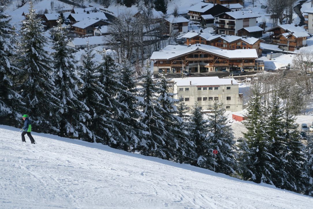 Solo skier heading up the piste