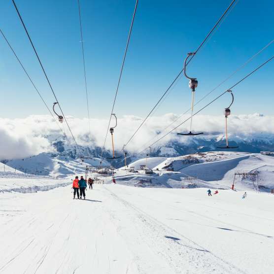 Solo skiers and snowboarders under the cable cars in Les Deux Alpes