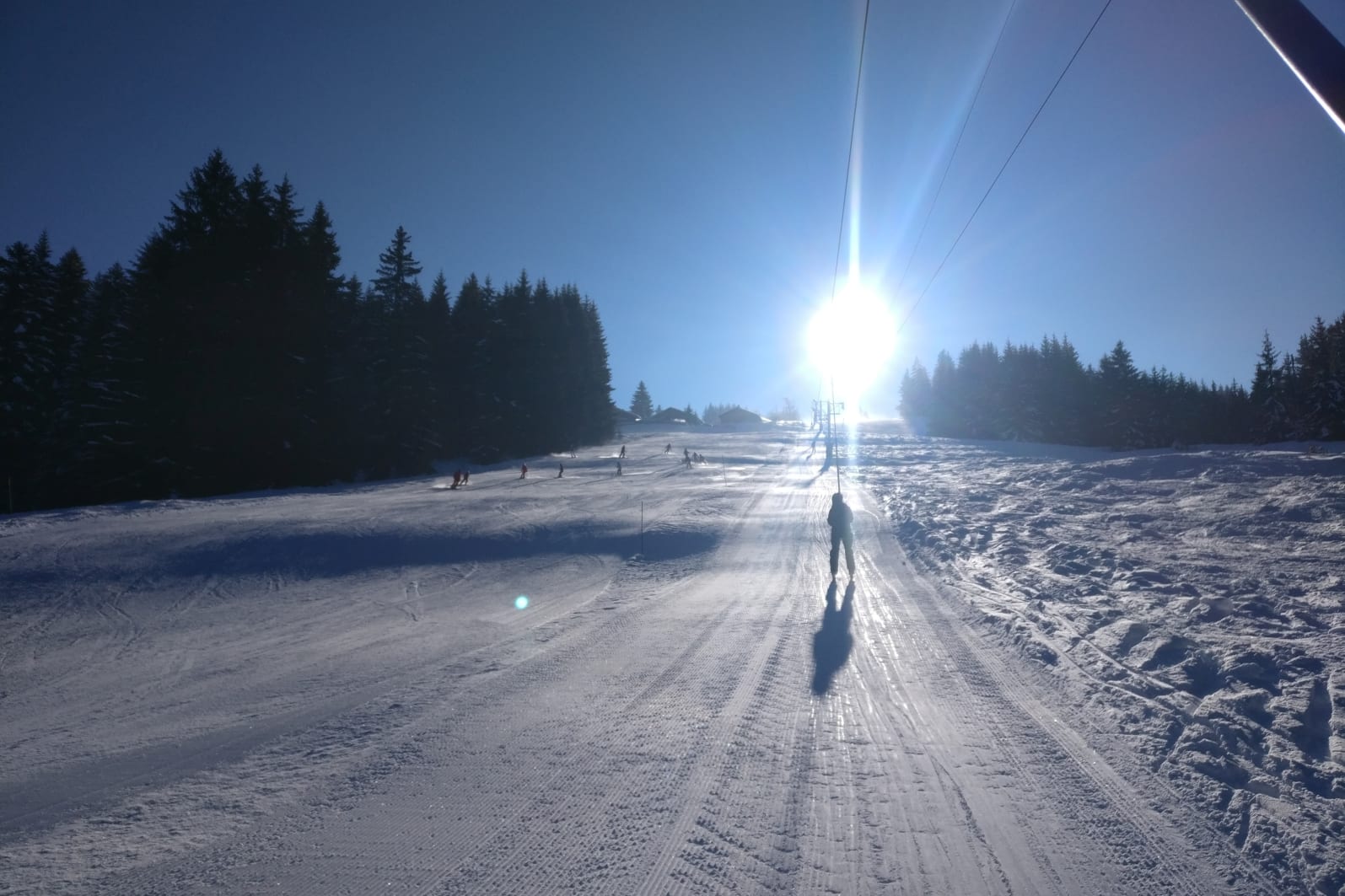 Skiers taking the Les Gets button lift