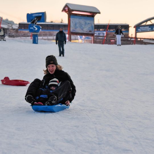 Woman and child sledging in Les Gets