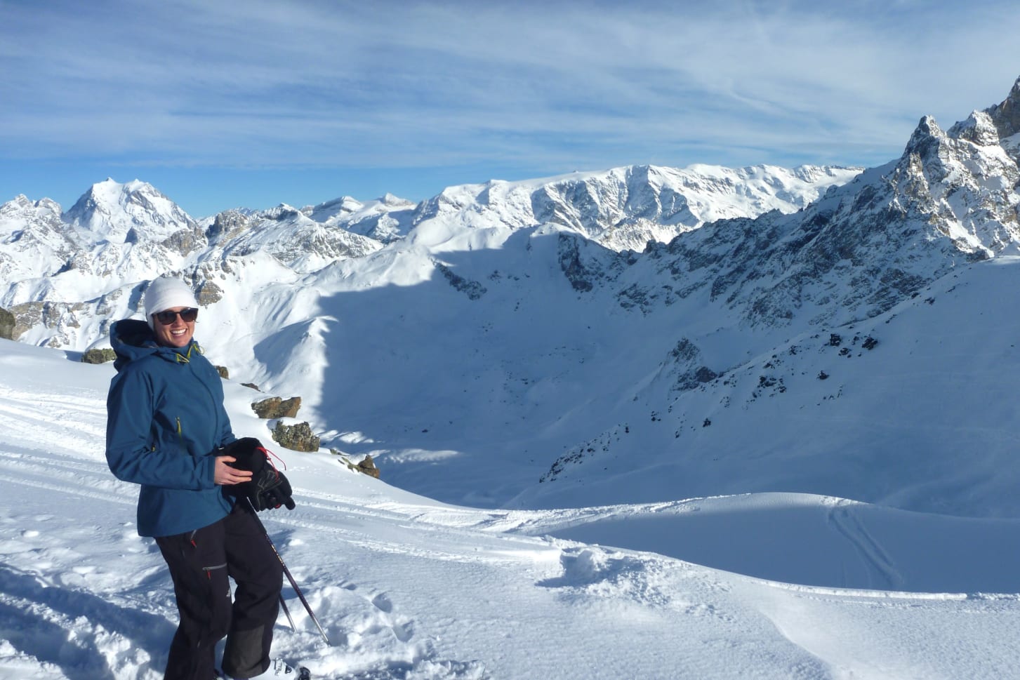 Lady skiing down mountain in blue jacket