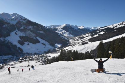 A solo snowboarder on a piste just above Saalbach